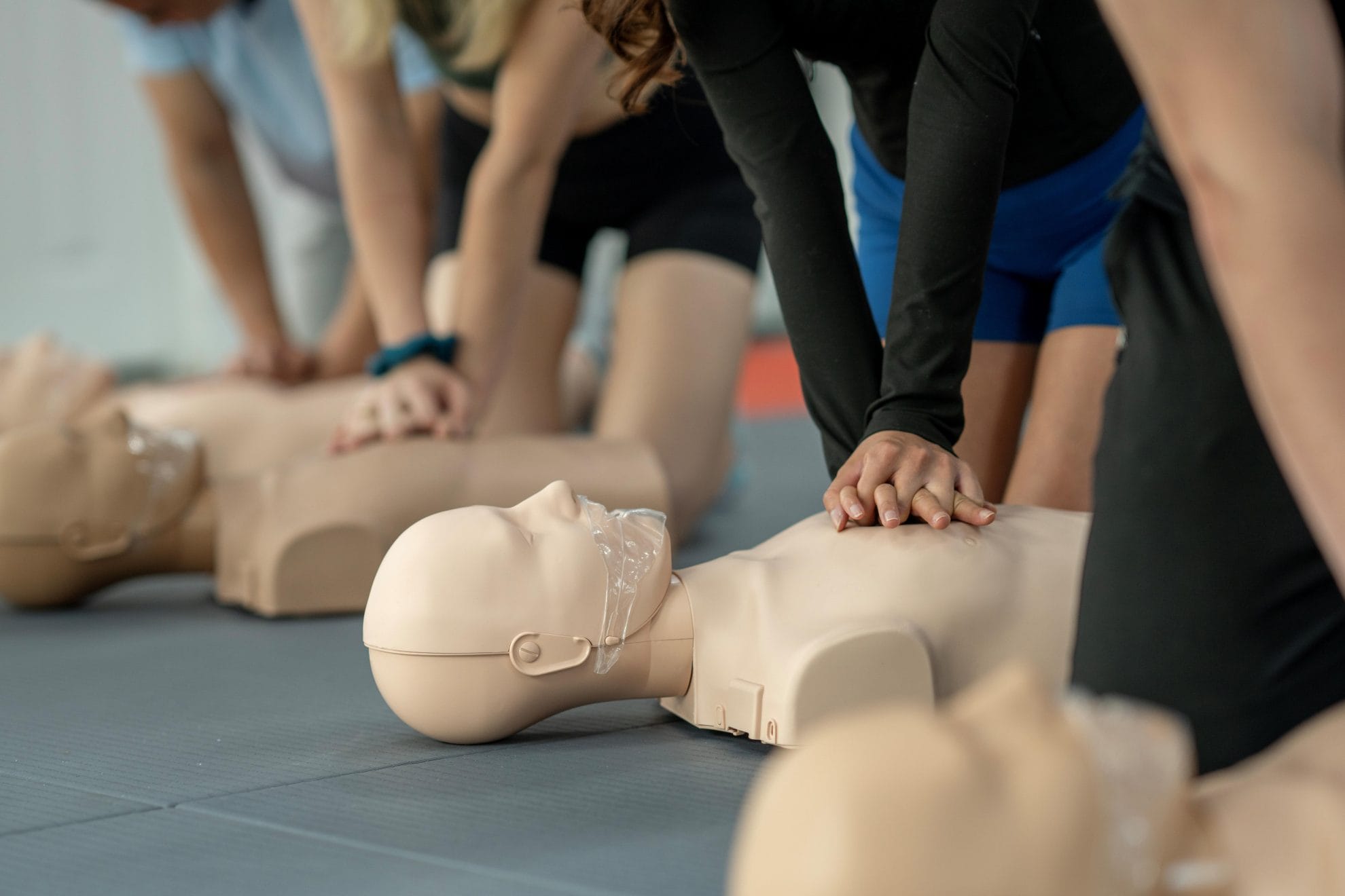 Woman practicing CPR chest compressions on a CPR dummy.