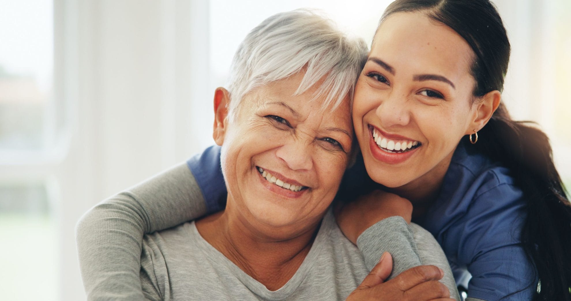Caregiver hugging senior woman.