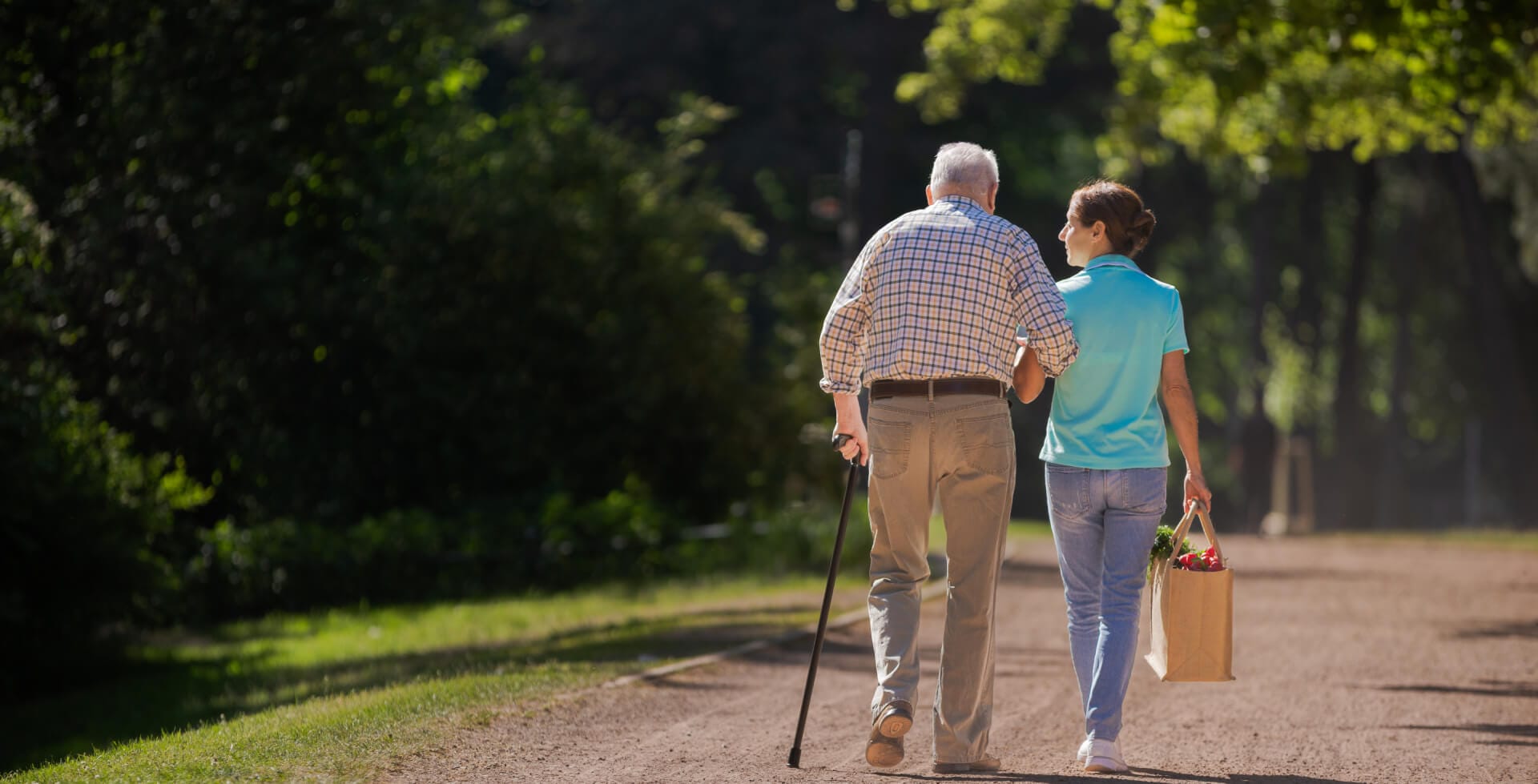 Caregiver supporting senior outdoors