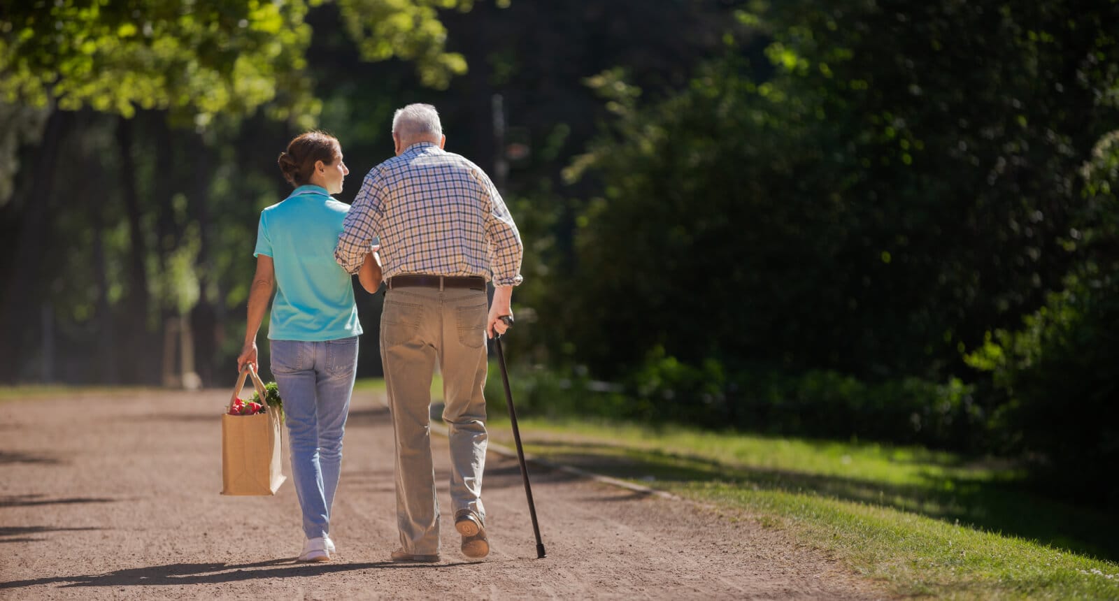 Caregiver supporting senior outdoors
