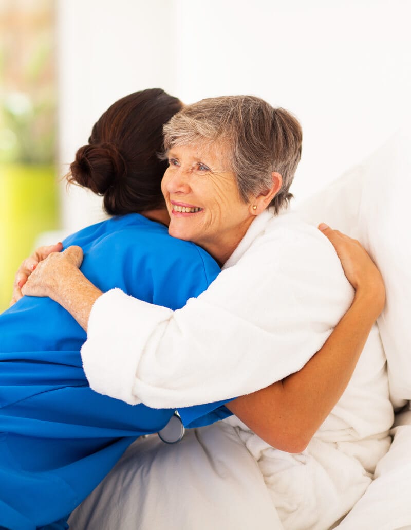Elderly woman hugging caregiver