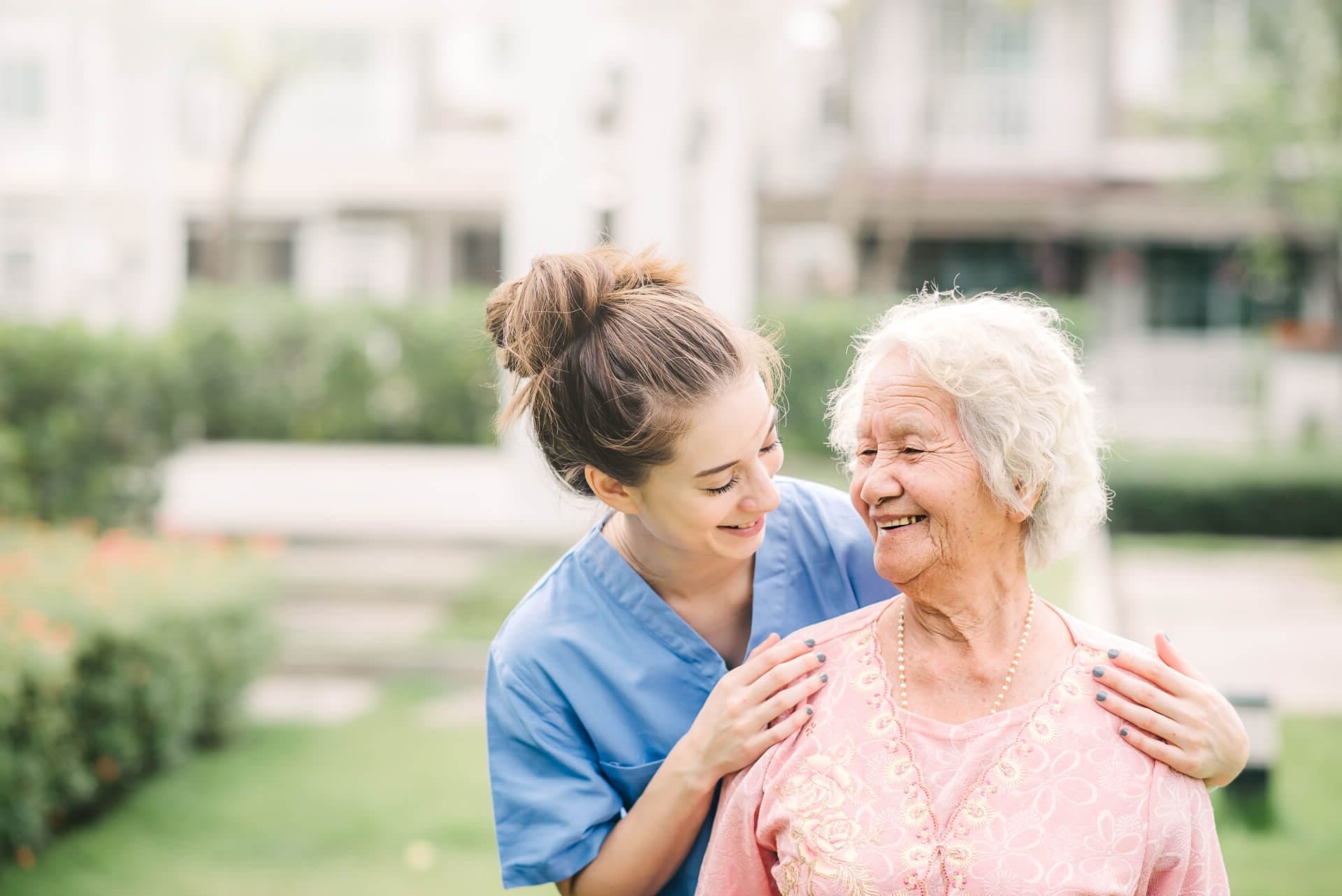 Caregiver with elderly woman outdoors