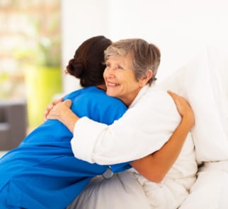 Elderly woman hugging caregiver