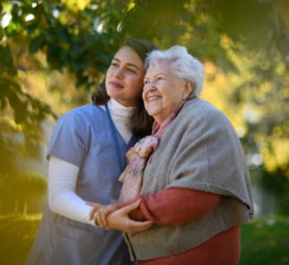 Nurse and senior walking outdoors