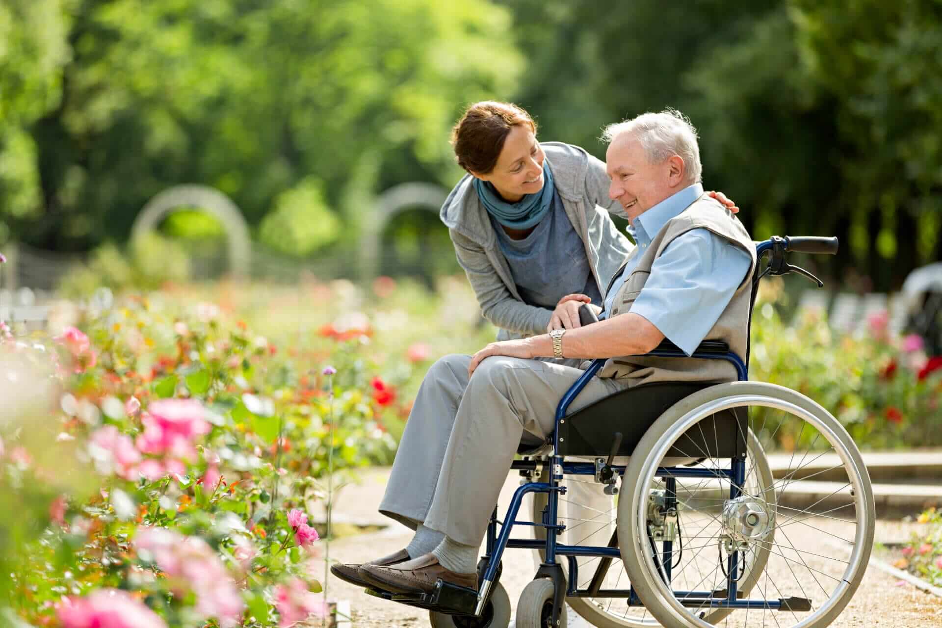 Caregiver pushing wheelchair in park
