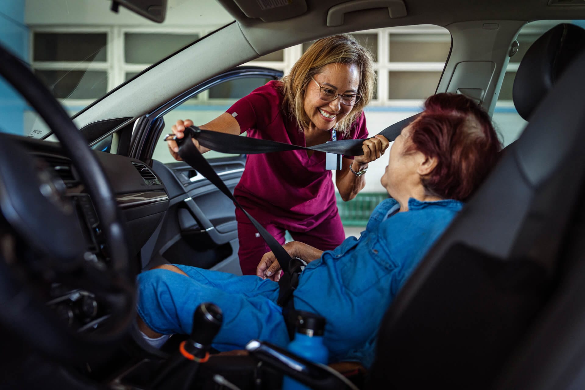 Caregiver assisting senior into car